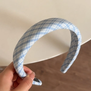 Detailed view showing the thick padded structure of a light blue checkered headband