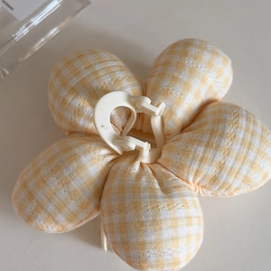 Detail of yellow and white plaid fabric flower hair claw clip with plush texture