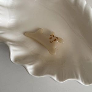 Cute cream acetate puppy hair clip for women with minimalist cartoon face on a shell tray