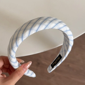 Detail of blue and white checkered fabric headband with premium interior brand label