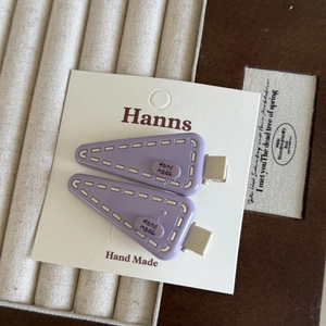 Détail de barrettes à cheveux triangulaires mauves avec texte gaufré hand made sur carte