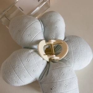 Floral light blue fabric flower hair claw clip with soft ribbed texture and metal spring