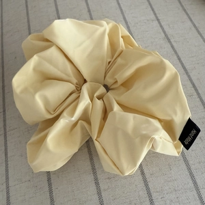 Detail of cream oversized scrunchie featuring matte texture and Hand Made label