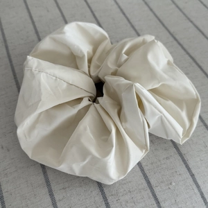 Minimalist cream oversized scrunchie hair tie on striped fabric for versatile styling