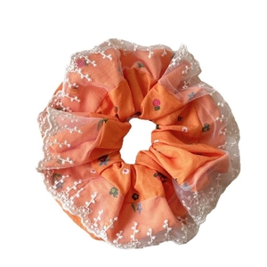 Handmade orange floral scrunchie with white lace trim for sweet elegant hair styling