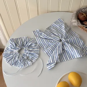 Close-up of blue and white striped fabric scrunchie set with matching square scarf