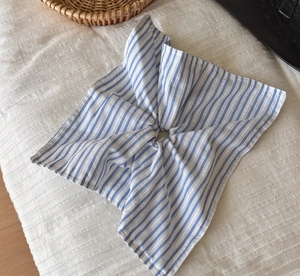 Detail of blue and white striped seersucker fabric scrunchie with soft cotton texture