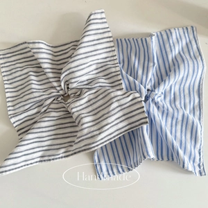 Detail of blue and grey striped fabric hair scrunchies with natural cotton texture
