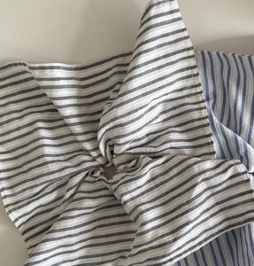 Close-up of blue and grey striped fabric texture of a large elastic hair scrunchie