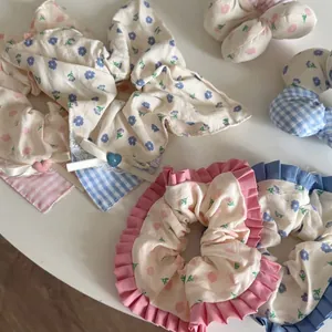 Détails de chouchous à fleurs et carreaux avec bords en dentelle et breloques