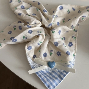 Détail d'un chouchou bleu fleuri avec dentelle, rayures et nœud en perle de cœur