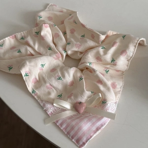 Détail du chouchou fleuri avec bordure en dentelle blanche et perle en forme de cœur