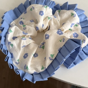 Chouchou floral avec motifs bleus et bords à volants pour coiffures élégantes