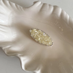 Barrette ovale élégante avec cristaux jaunes et strass blancs dans un plat en coquille