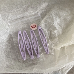 Vue détaillée de 4 barrettes à cheveux mates violet clair dans un sachet artisanal