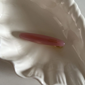 Détail de la pince à cheveux artisanale en acétate rose poudré avec ressort métallique