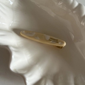Détail d'une pince à cheveux en acétate marbré avec lettrage doré France Handmade