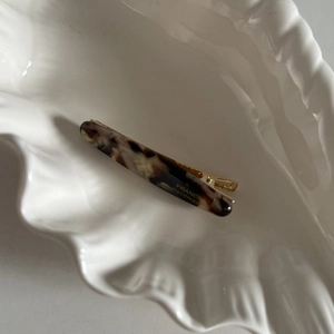 Vue détaillée de la pince à cheveux en acétate écaille de tortue dans un plateau en coquillage