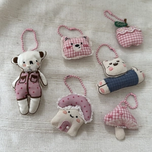 Detailed view of handmade pink polka dot bear and plush fabric charms with bead chains