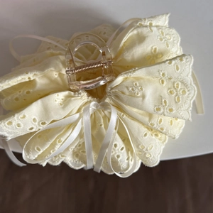 Detail von cremefarbener Haarklammer mit Stickerei-Spitze und Schleifen-Akzent