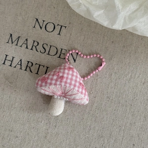 Detail of pink plaid mushroom plush pendant with white pearls and pink bead chain