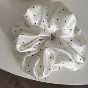 Elegant oversized cream satin scrunchie with black polka dots and a silky glossy finish