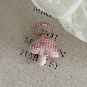 Detail of pink plaid mushroom fabric charm with white pearl beads and pink chain