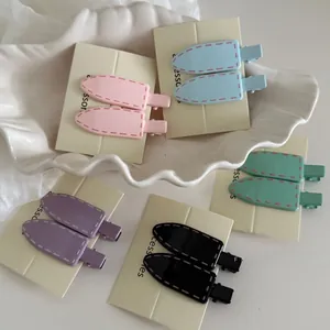 Detail view of colorful matte alloy hair clips with decorative stitching texture