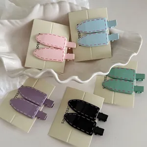 Five-color pastel hair clips set with minimalist stitching detail on a ceramic display