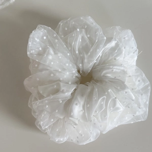 Makroaufnahme des weißen Seersucker-Stoffs mit Punkten auf dem flauschigen Haargummi