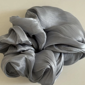 Lustrous silver grey oversized pleated satin scrunchie with vertical texture and soft sheen