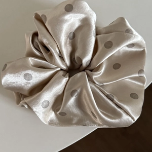 Polka dot satin scrunchie in champagne silk-like fabric with rich ruffled pleats