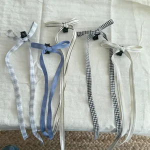 Vue détaillée de cinq pinces à cheveux avec de longs rubans à motifs à carreaux