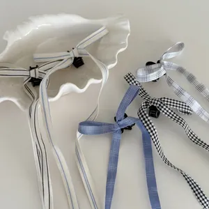 Barrettes à nœud style ballet avec de longs rubans à carreaux et rayures dans un plat