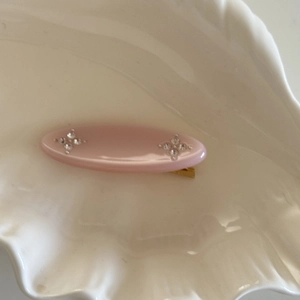 Detailaufnahme einer rosa Haarspange aus Acetat mit glitzernden Strass-Blumenakzenten