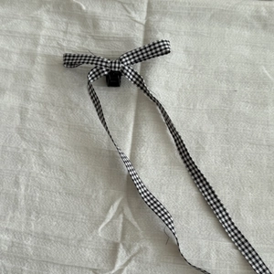 Détail d'une pince à cheveux nœud vichy noir et blanc avec de longs rubans fluides