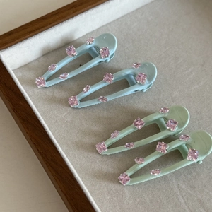 Chic mint green and pink rhinestone hair clips set displayed on a velvet tray