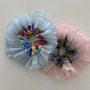 Detail of pink and blue organza scrunchies with pleated ruffles and floral patterns