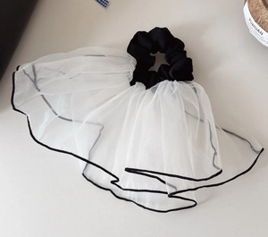 Detailed view of large mesh scrunchie with contrasting black hem and white organza