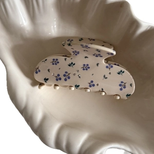 Pince à cheveux fleurie avec motifs bleus et strass sur base blanc cassé