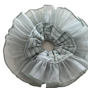 Handmade organza scrunchie with green stripes and floral embroidery on white backdrop