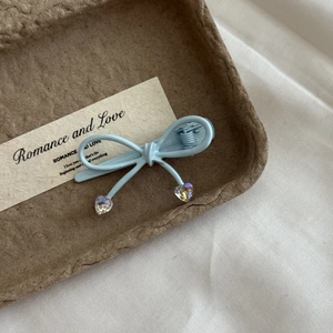 Détail de la pince à cheveux ruban bleu clair avec pendentifs en cristal de coeur