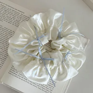 Chouchou en soie à ruban bleu et perles sur livre ancien, style ballet élégant