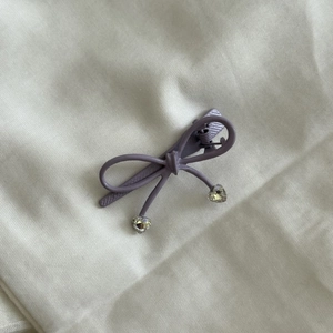 Barrette à cheveux nœud violet avec cristaux en cœur sur tissu couleur ivoire