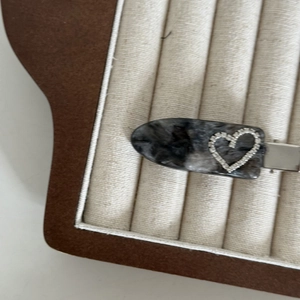 Nahaufnahme der Haarspange aus Acetat mit Marmormuster und glitzerndem Strass-Herz