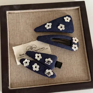 Set of four blue denim hair clips with silver floral accents for women and girls