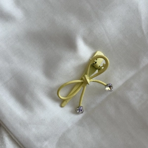 Barrette à cheveux nœud jaune avec strass en forme de cœur sur tissu blanc