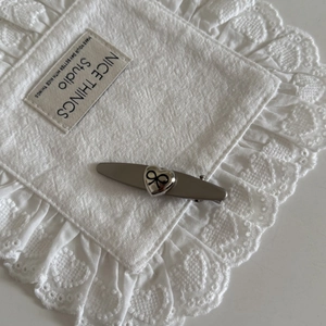 Matte silver hair clip with heart motif and infinity symbol on white lace background