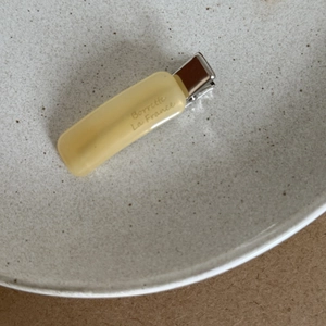 Detailed view of yellow acetate hair clip with silver metal back on ceramic plate