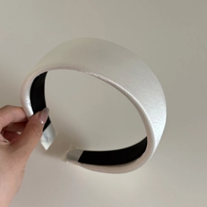 Elegant off-white satin padded headband with a wide design and smooth glossy finish